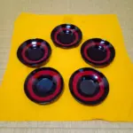 村上の漆器、乾漆の研ぎ出し茶托５枚、黄色い布の上に星形に並べてある。