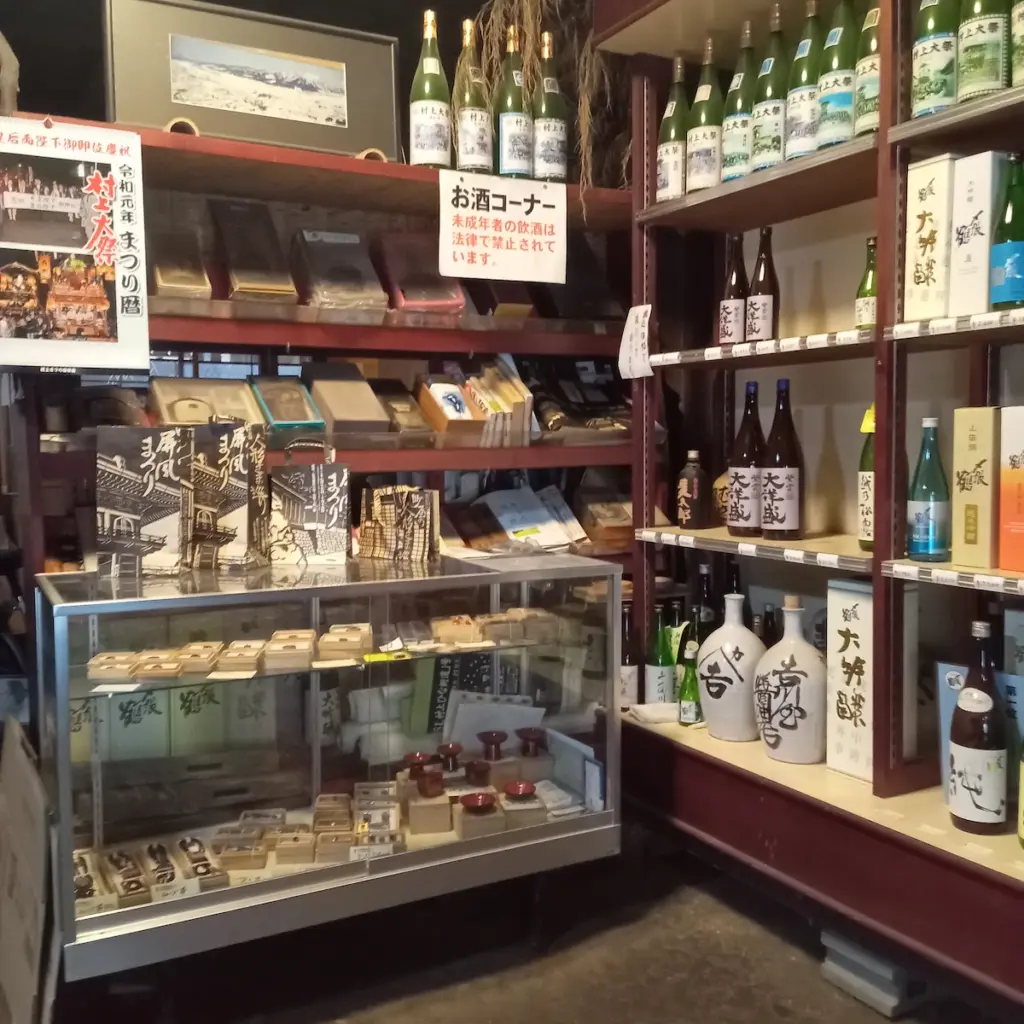 土間の一角、お酒コーナーには村上大祭の記念ラベルの地酒が陳列されており、ショーケースには村上木彫堆朱が展示されていました。