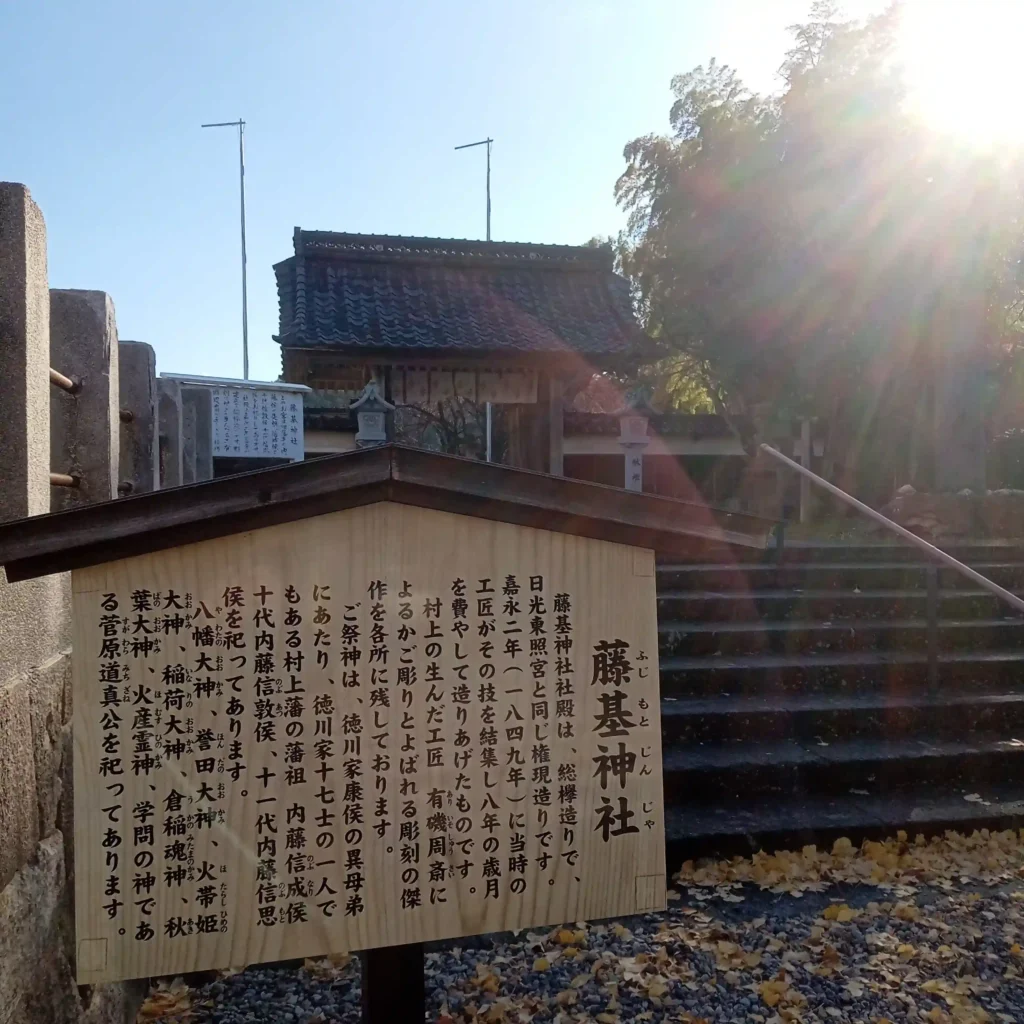 総門前。藤基神社の由緒を書いた木製の案内板です。