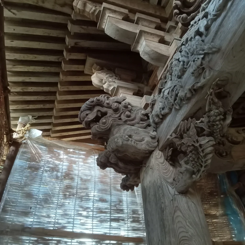 有磯周斎の彫刻。左側の獏と獅子、虹梁の藤の彫刻を斜め下から撮影。