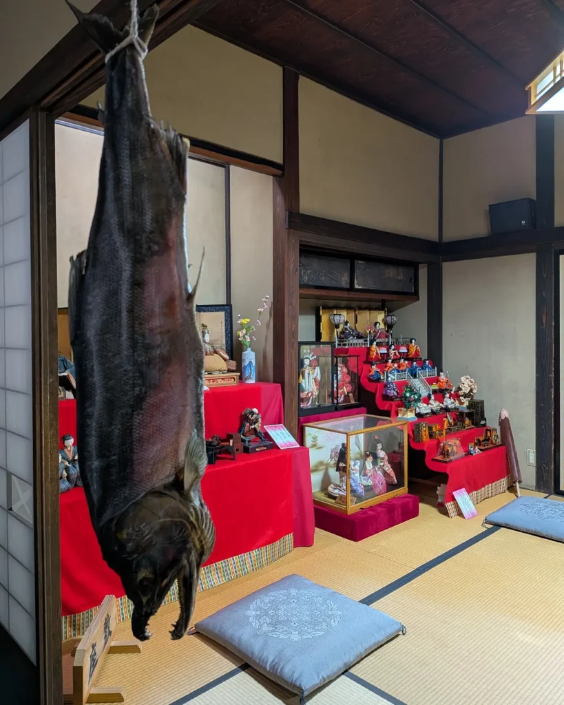 吊るされた鮭と、奥に並ぶ人形さまたち。村上らしい光景が同じ空間に。