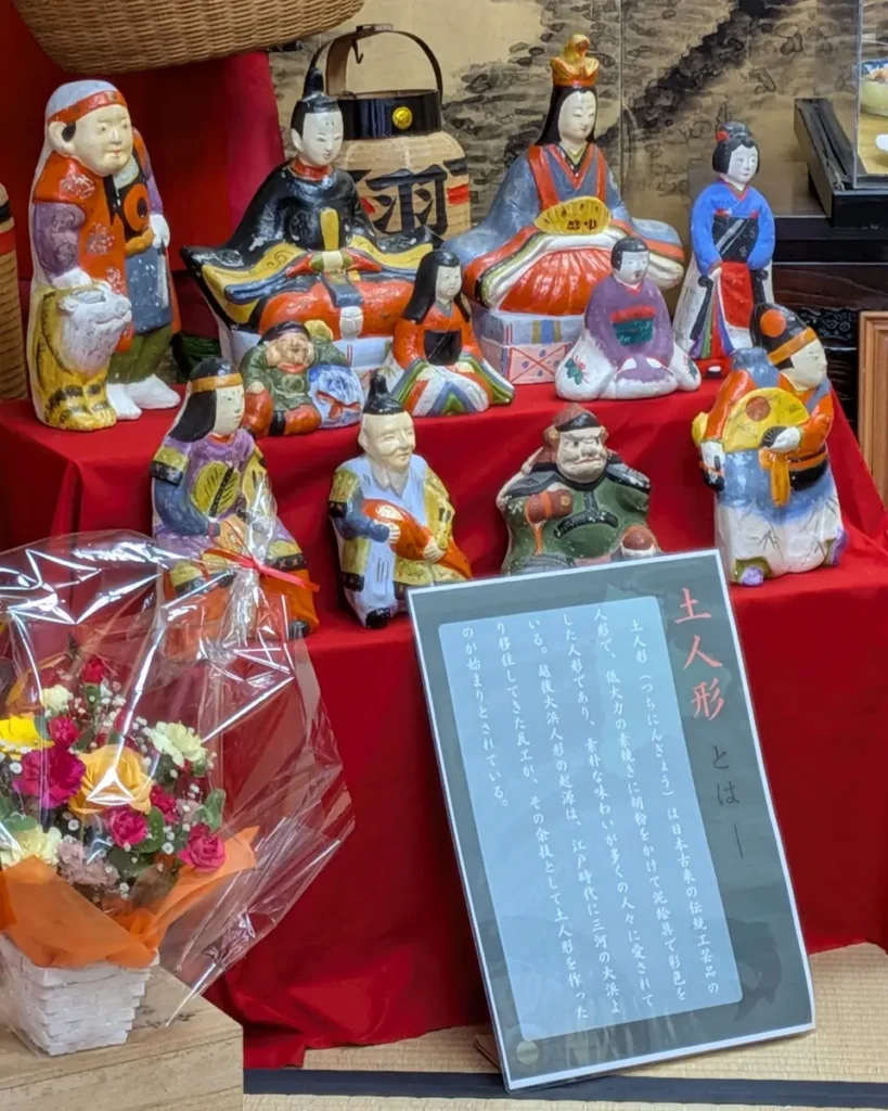 緋毛氈の上には素朴でユーモラスな土人形が並ぶ。