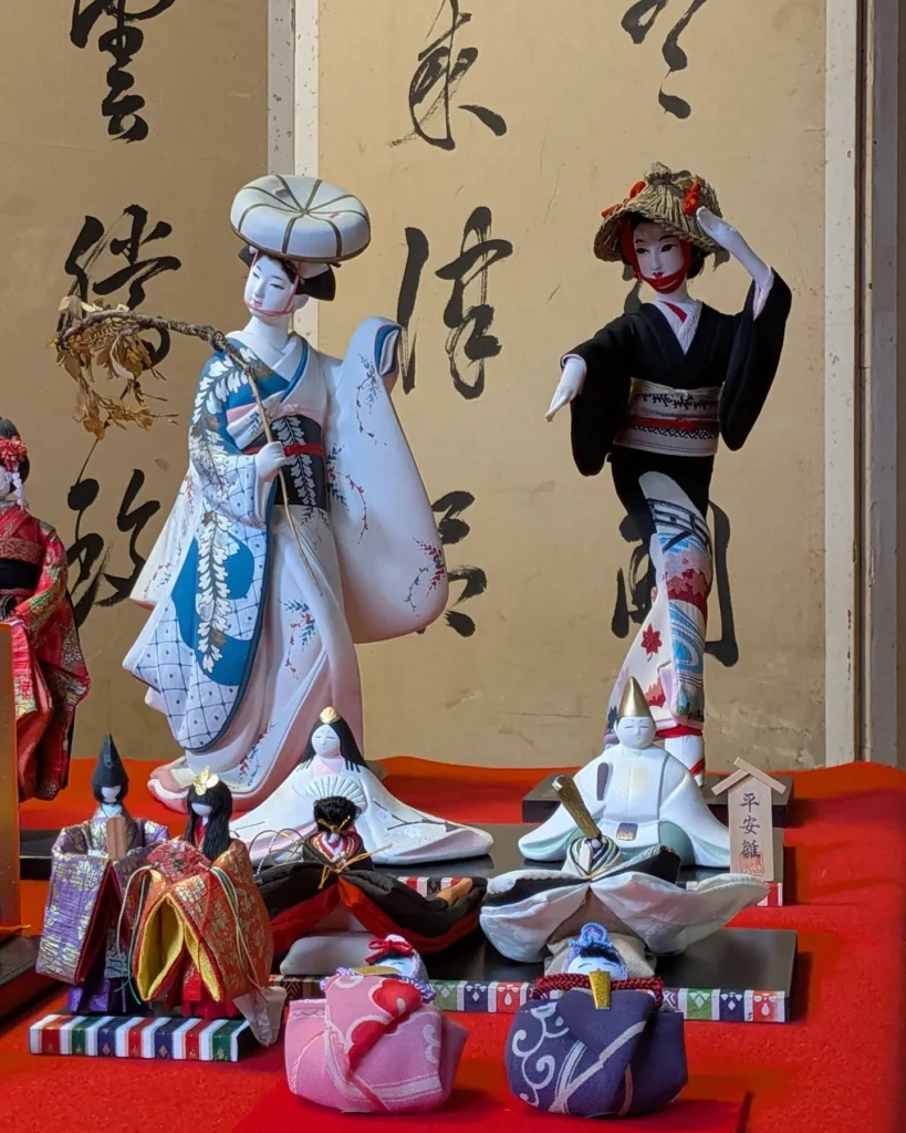 藤柄の振袖姿の博多人形と、編笠の踊り人形
