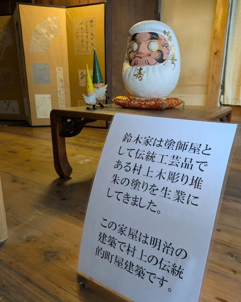 達磨と、鈴木家が村上木彫堆朱の塗師だったことの説明書き。