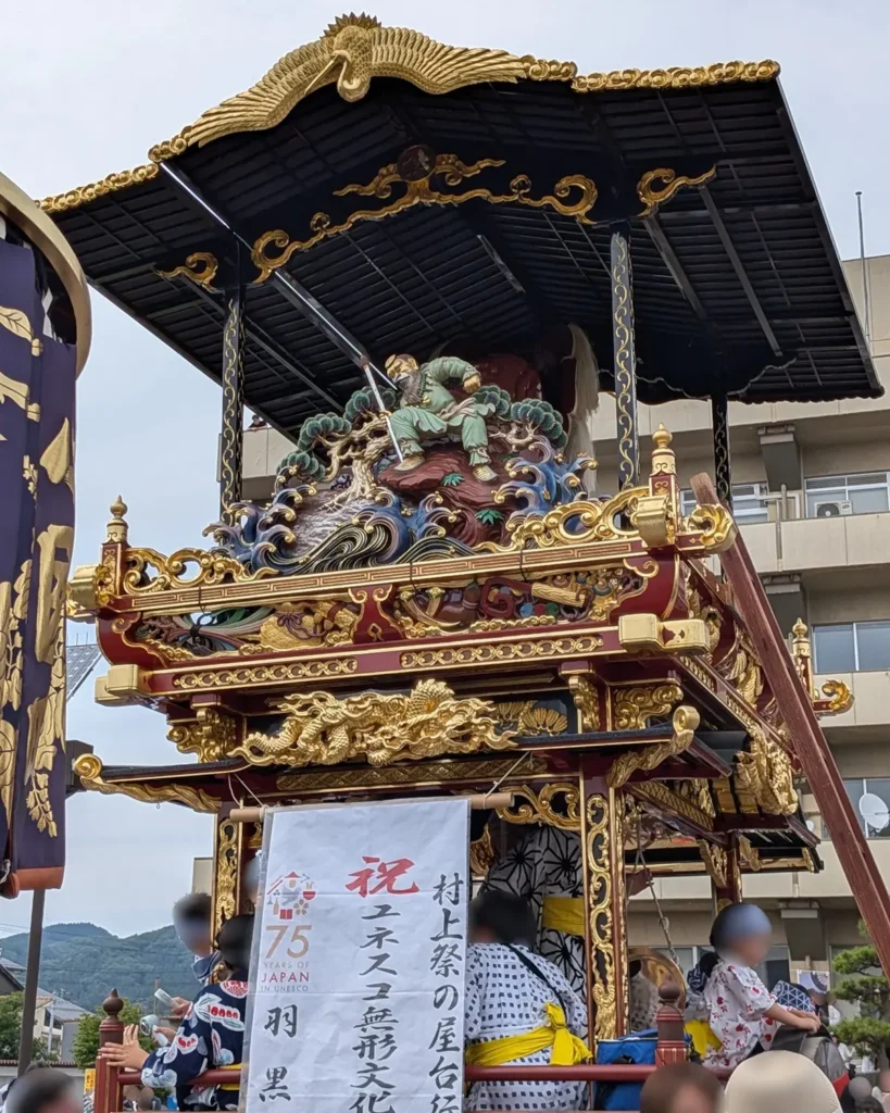 14番　羽黒町（しゃぎり屋台）

・制作年：平成10年（1998年）
・制作者：細野実、平山鋼平
・乗せ物：「天狗面」。羽黒神社本殿の黒白一対のうち、白面を模したもの。