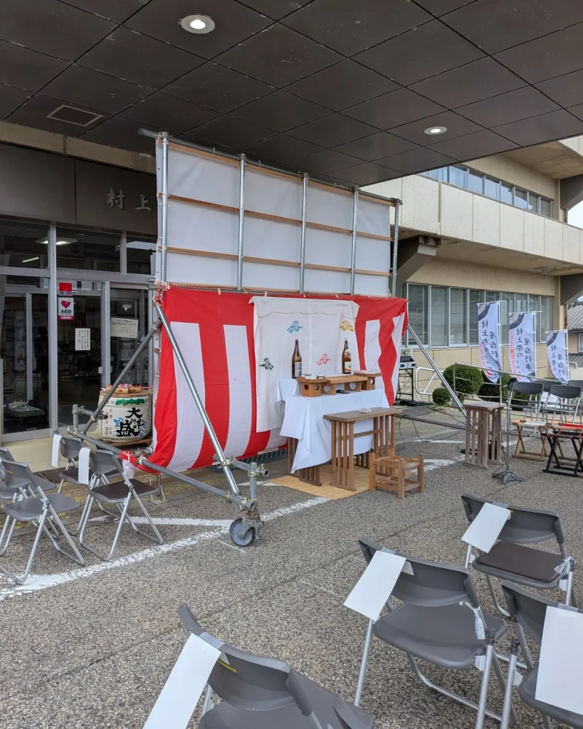 市役所庁舎の正面玄関前でユネスコ無形文化遺産登録祝賀イベントの式典に向けた祭壇や椅子が整えられた様子
