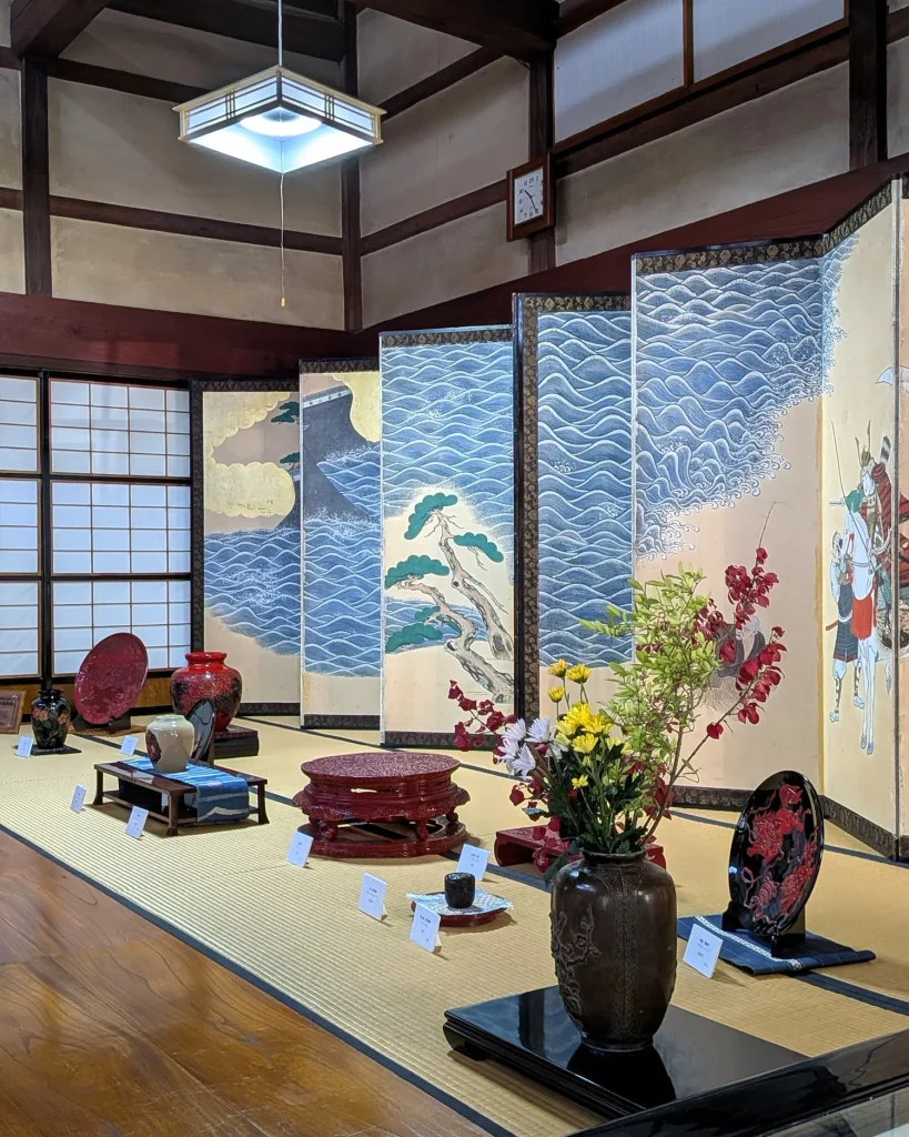 町屋の屏風まつりの屏風と村上木彫堆朱の作品が並ぶ村上市町屋造観光案内所