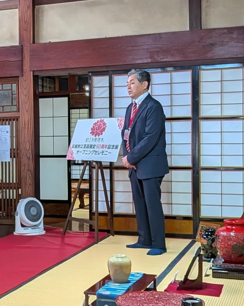 村上木彫堆朱 伝統的工芸品指定50周年記念展のオープニングセレモニーで挨拶する小杉和也代表理事