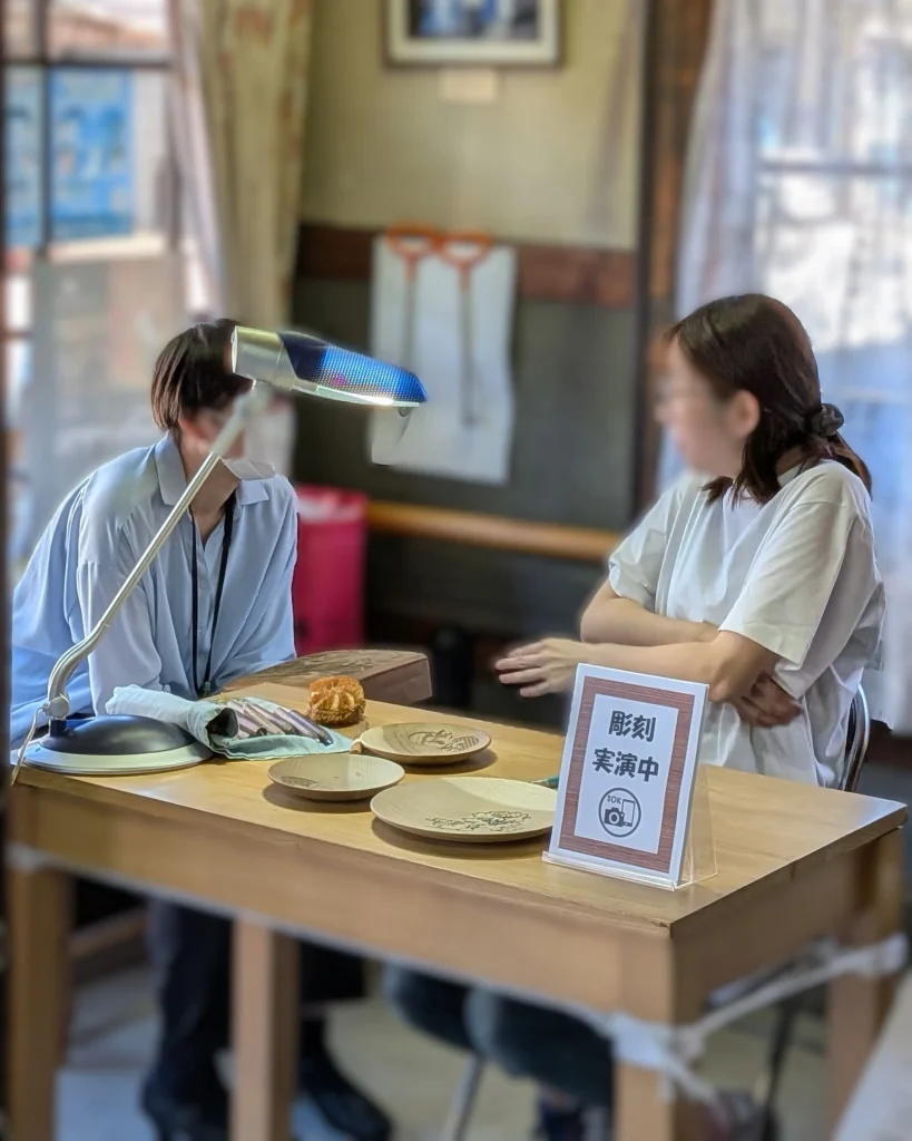 若手の彫り師と地域おこし協力隊の方が実演席で話を交わす様子