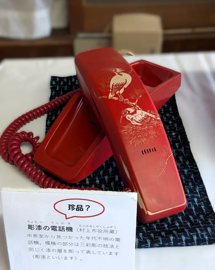 漆の層を彫って鳥の文様を表した彫漆の電話機