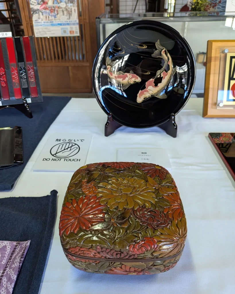 飾り皿とともに展示された花文の村上木彫堆朱の箱物