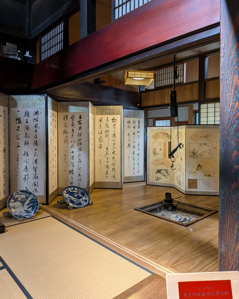 吉川酒舗の囲炉裏と自在鉤のある町屋に展示された書と扇面の屏風
