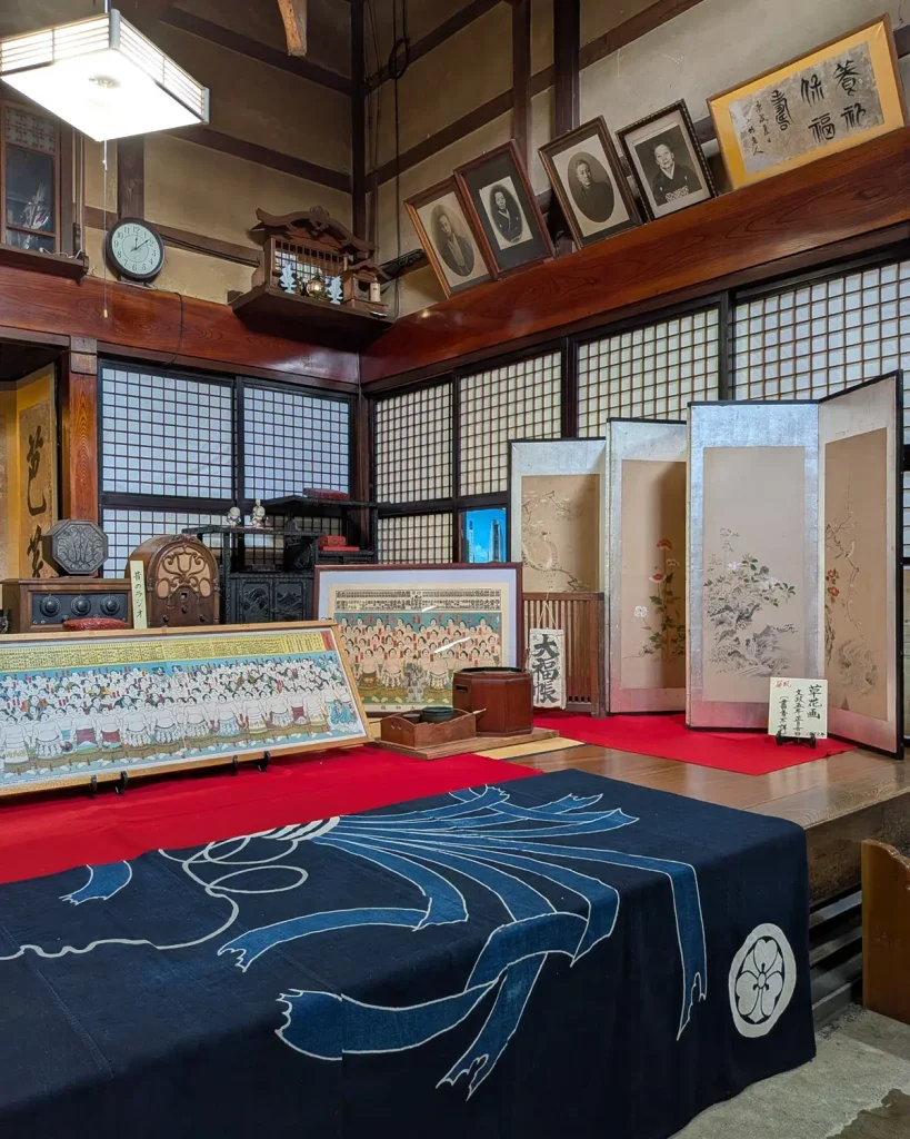 益田甚兵衛酒店に展示された草花を描く屏風と木製の昔のラジオ
