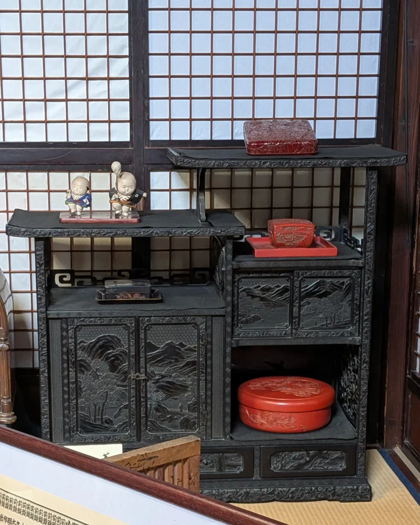 益田甚兵衛酒店に展示された堆黒の飾り棚と赤い村上堆朱の器や小箱
