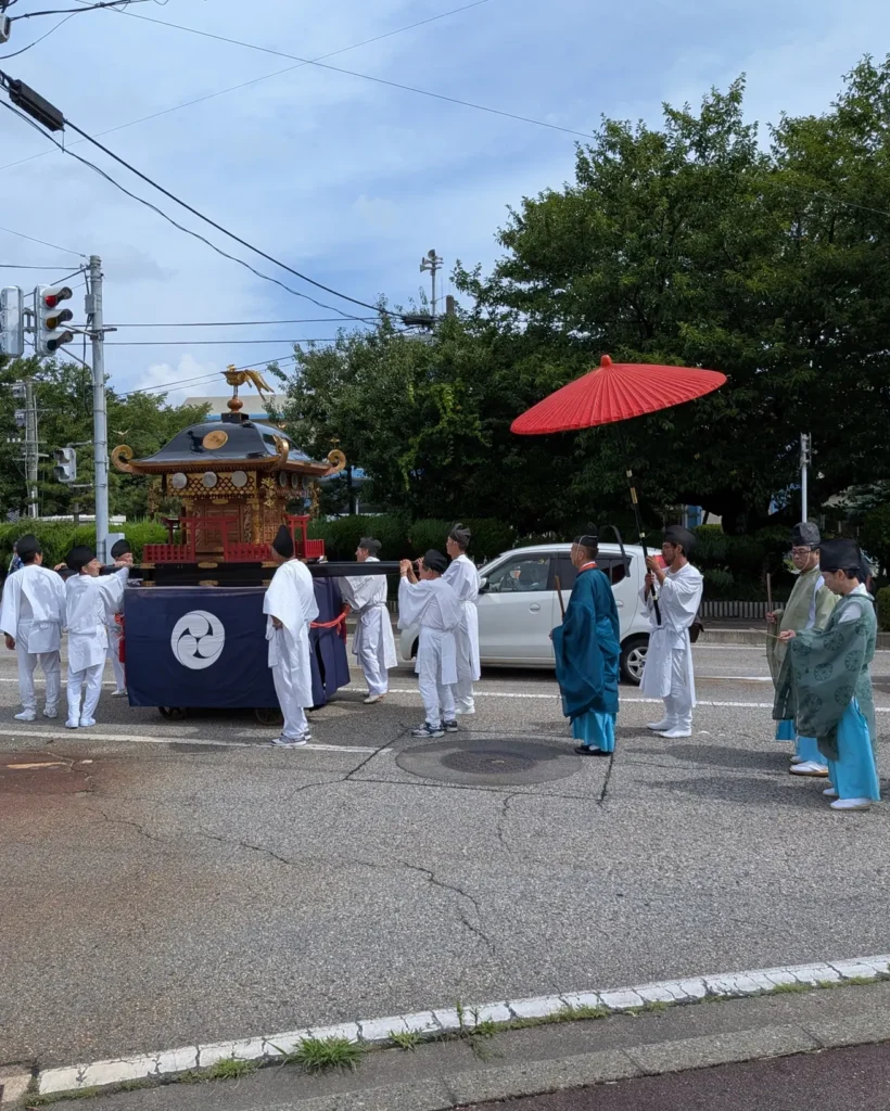 瀬波大祭で西奈彌神社の神輿が国道345号を渡御する様子