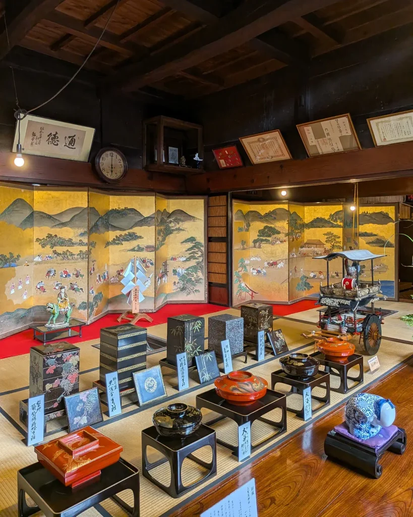 千年鮭きっかわの町屋に展示された金地の屏風と漆器、おしゃぎりの模型