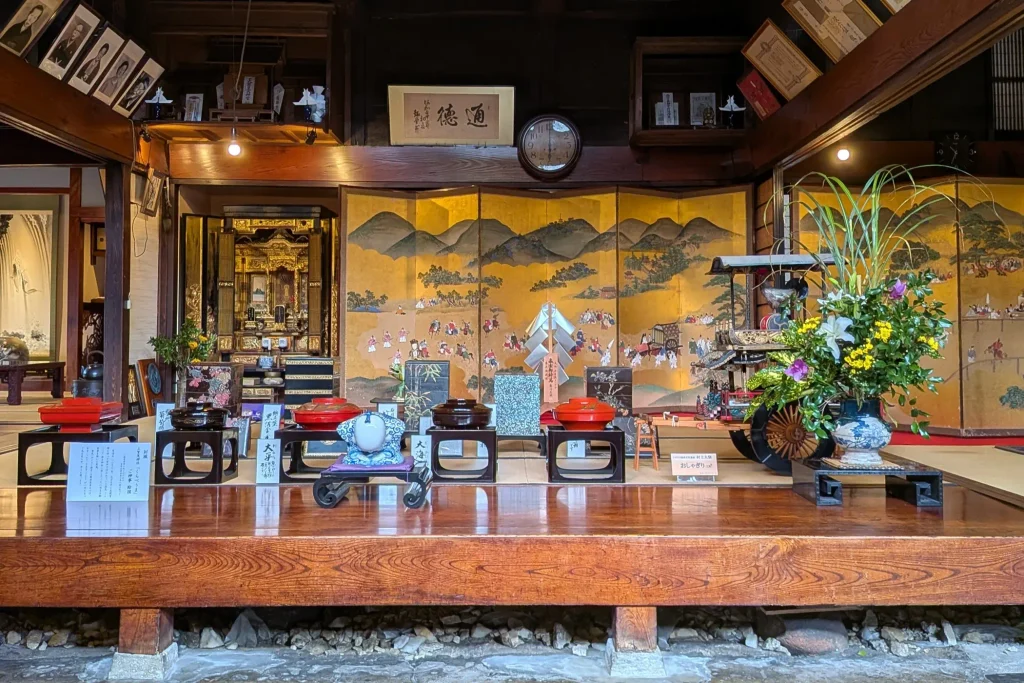千年鮭きっかわの金地の屏風と漆器を正面から見た展示風景
